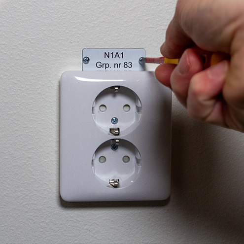 Eluttag med skylt i graverad plast