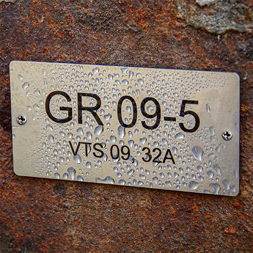 Rostfri metallskylt på rostig bakgrund